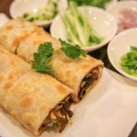 Beef Roll · Slices of slow-simmered beef, red onions, scallions, cucumber and cilantro wrapped in a flak...
