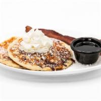 Chocolate Chip Hot Cakes · Two Buttermilk Hot Cakes with Chocolate Chips, Topped with Whipped Cream.  Served with Bacon