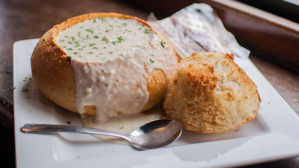 Clam Chowder · Hot and creamy new england style chowder with chunks of potatoes and clams served in a toasted sourdough bread bowl