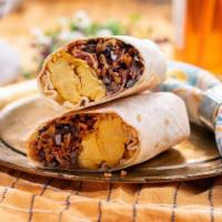 Le Mexican Breakfast Wrap · flour tortilla rolled up + stuffed with eggs, bacon, jack cheese, rice, black beans + salsa.