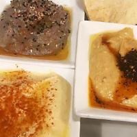 Hummus Trio · Combination of traditional hummus, spicy hummus and black bean hummus served with pita bread.