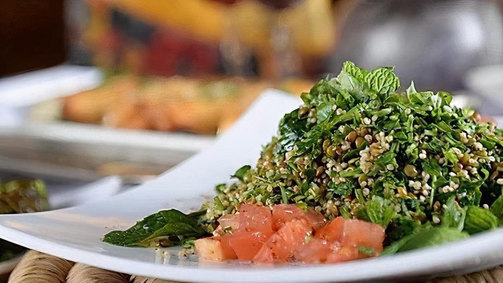 Tabbouleh Salad · Diced tomatoes and onions mixed with bulgur wheat and chopped parsley tossed with fresh squeezed lemon juice and olive oil.