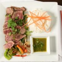 Crying Tiger · Tender beef flame grilled with veggies, served on top of blanket green salad and side of spi...