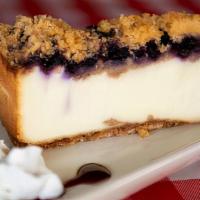 Lemon Blueberry Crumb Cheesecake · A graham cracker base topped with
a creamy lemon cheesecake and
finished with blueberry stre...