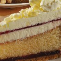 Lemon Raspberry Cheesecake · The buttery honey graham cracker crust
holds moist lemon cake between layers
of raspberry ja...