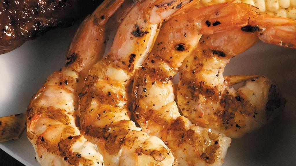 Fire-Grilled Jumbo Shrimp · Fire-grilled jumbo shrimp brushed with garlic butter served over a bed of rice.