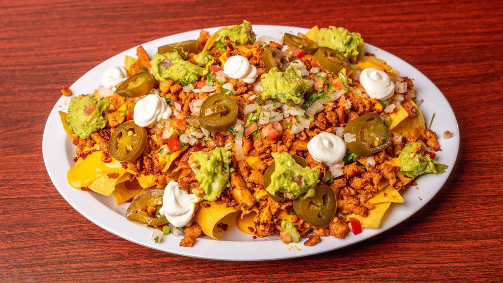 Super Nacho Plate · Nacho chips with nacho cheese sauce, any meat, jalapenos and pico de gallo, refried beans, sour cream, and guacamole