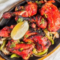 Tandoori Chicken · Rocky jr. Free range chicken marinated in yogurt, garlic, herbs and spices served on a sizzl...