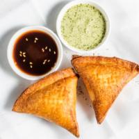 Vegetable Samosa (2) · Triangular pastry stuffed with potatoes and peas and nuts.