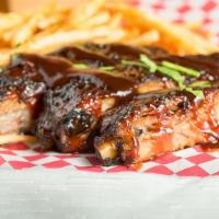 Pork Ribs (For 3) · Smoked pork ribs with BBQ drizzle.
