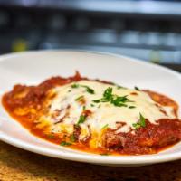 Eggplant Parmigiana · Breaded sliced eggplant baked with marinara sauce and topped with mozzarella cheese.