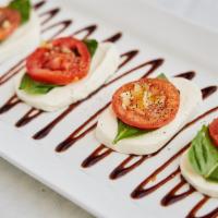 Caprese Salad · Fresh sliced mozzarella, sliced roma tomatoes, basil, garlic and fresh olive oil.