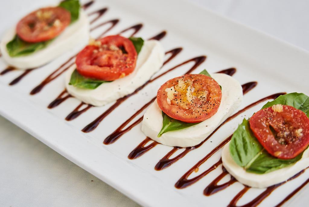 Caprese Salad · Fresh sliced mozzarella, sliced roma tomatoes, basil, garlic and fresh olive oil.