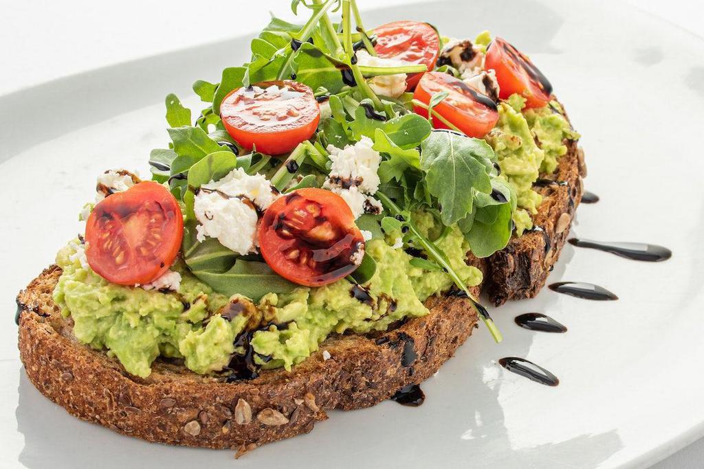 Feta Avocado Toast · Artisan grain bread lightly toasted and topped with fresh avocado, arugula, cherry tomatoes, feta cheese and balsamic drizzle.