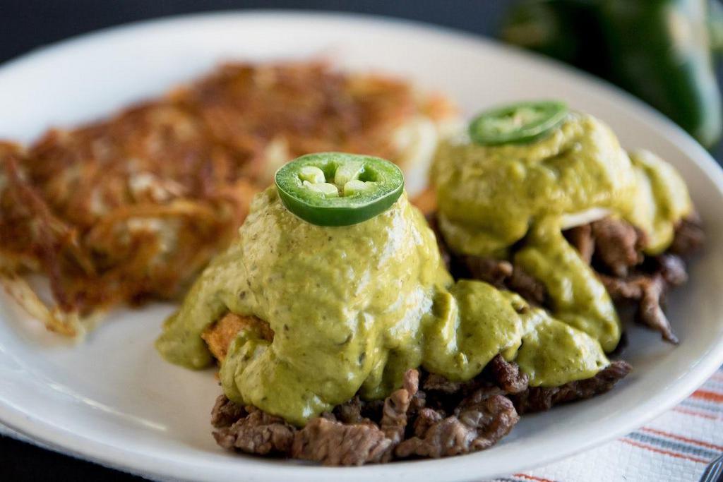 Border Benedict · Poached eggs, seasoned carne asada and sweet corn cakes topped with our homemade poblano sauce and fresh sliced jalapeno.