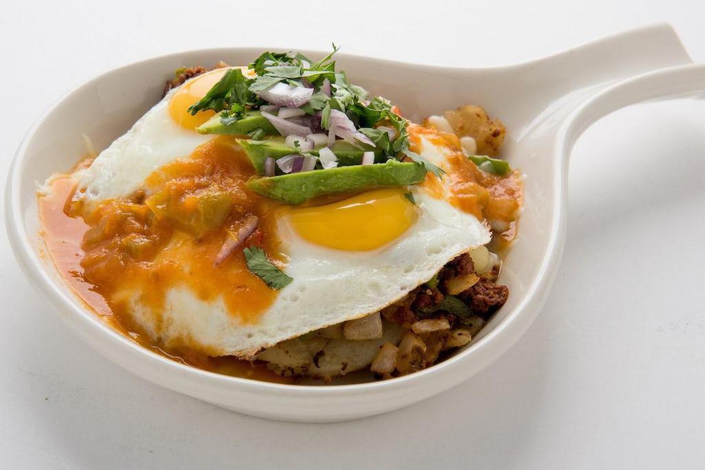 Ranchero Skillet · Homefried potatoes sauteed with spicy chorizo, fresh chopped serrano peppers and onions.  Topped with Jack cheese, sunny side up eggs, avocado, red onion, cilantro and ranchero sauce.