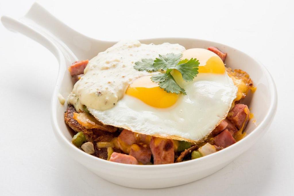 Country Skillet · Homefried potatoes sauteed with diced ham, bell peppers and onions.  Topped with sunny side up eggs and our homemade country gravy.