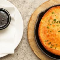 Skillet Cornbread · Sharp cheddar, creamed corn and garlic, honey butter and house made seasonal jam on the side.