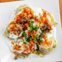 Mantoo · Stuffed dumplings with beef, onion and cilantro. Topped with tomato sauce, lentils and spices.