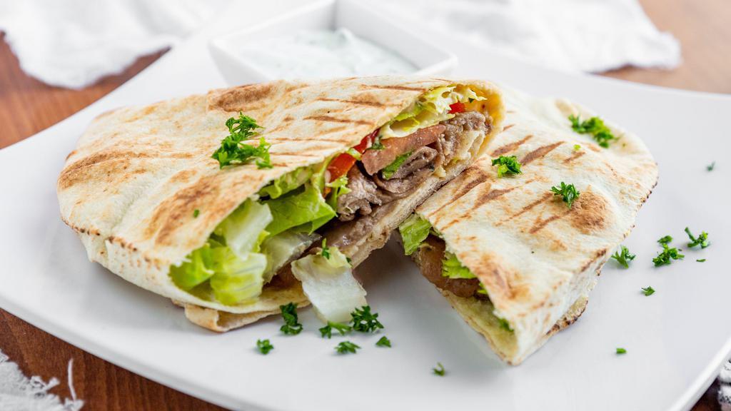 Lamb-Beef Gyro Wrap · Lamb and beef wrapped in a pita bread with lettuce, tomato, onion, hummus, jalapeños comes with garlic sauce & house sauce.