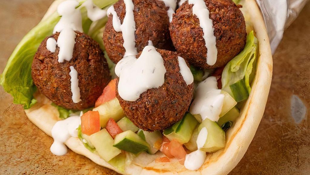 Falafel Gyro Wrap · Falafel wrapped in a pita bread with lettuce, tomato, onion, hummus, jalapeños comes with garlic sauce & house sauce.