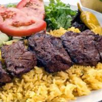 Beef Kabob Plate · Thick cuts of juicy steak grilled on a skewer, served with mixed green salad, rice pilaf, pi...