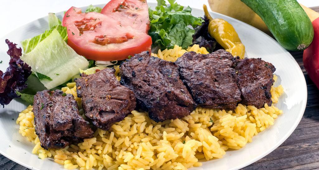 Beef Kabob Plate · Thick cuts of juicy steak grilled on a skewer, served with mixed green salad, rice pilaf, pita bread.