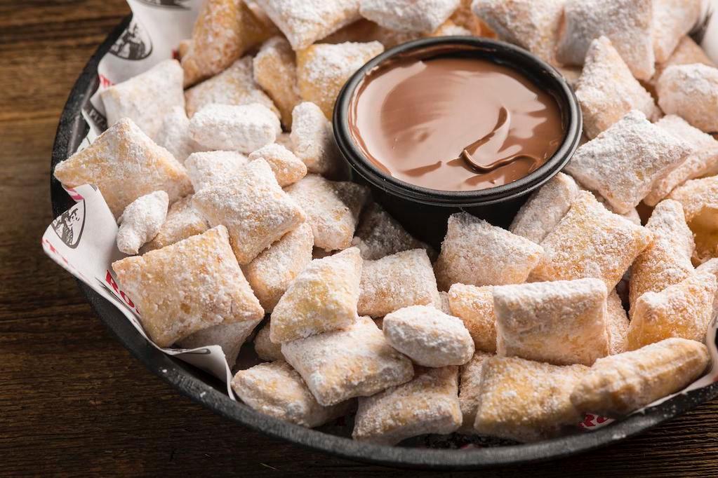 Zeppole · Bite-sized pieces of crispy dough tossed in powdered sugar & paired with rich nutella hazelnut spread.