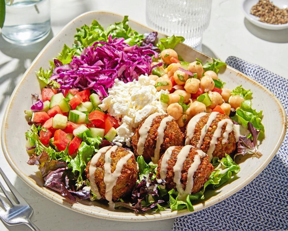 Luna Vida Vegetarian Bowl · Housemade falafel served on top of a bed of lettuce with lemon vinaigrette, Greek cabbage, feta, chickpea salad, cucumber and tomato, drizzled with vegan tahini sauce. . *Vegetarian, Gluten Free, High Protein (23G), 730 Cals