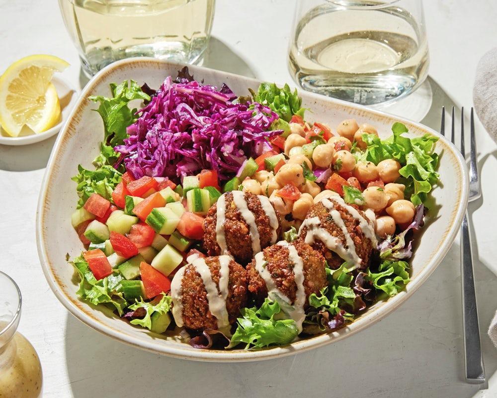 Luna Vida Vegan Bowl · Housemade falafel served on top of a bed of lettuce with lemon vinaigrette, Greek cabbage, chickpea salad, cucumber and tomato, drizzled with vegan tahini sauce.. *Vegan, Gluten Free, High Protein (23G), Low Cal (650 Cals)