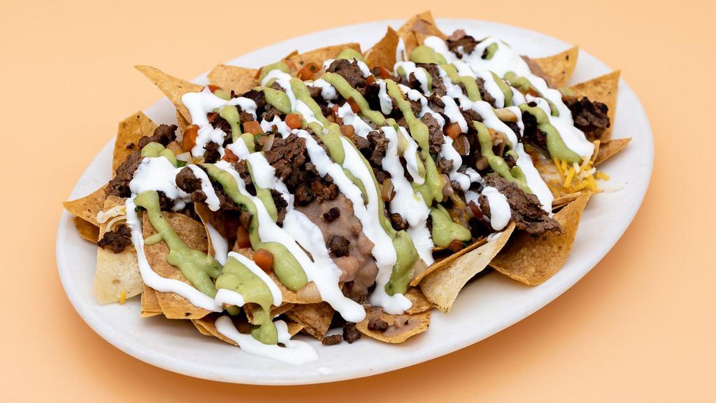 Nachos · (Choice of plain cheese nachos or with meat.) Comes with refried beans, melted shredded cheese, pico de gallo, fresh guacamole, and sour cream.