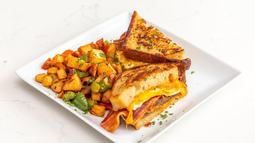 Breakfast French Toast Sandwich · Turkey sausage, fried egg, bacon, and cheddar on sourdough bread served with breakfast potatoes.