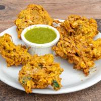 Vegetable Pakora · Deep-fried onion, spinach, cabbage mixed in chickpeas flour batter. Served with mint chutney.