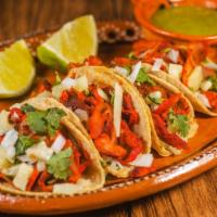 Al Pastor Tacos · Three of our classic tacos made of corn tortillas filled with juicy, marinated pork, onions,...