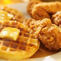 Chicken & Waffles · Two fried chicken breast pieces with two large waffles served with butter and syrup.