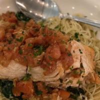 Salmon Milano · Grilled salmon with tomatoes, basil, garlic, and served over spinach with capellini sauteed ...