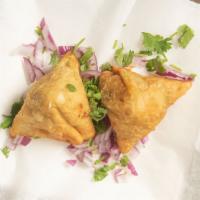 Samosa · Crispy turnover filled with potatoes and peas served with mint and tamarind chutney.