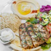 Salmon Kabob Plate · Grilled Wild-Caught Alaskan Salmon with a side of Rice, Hummus, Greek Salad & Pita Bread.