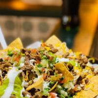 Super Nachos · Super nachos are LOADED with crispy nachos, beans, melted cheese, sour cream, guacamole, pic...