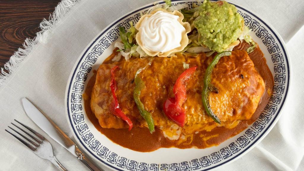 Fajita Burrito · Steak or chicken, grilled onion, peppers, and refried beans, flour tortilla, topped with red chile sauce. guacamole and sour cream.