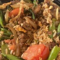 Thai Fried Rice · Stir-fried rice with egg, peas, carrots, green onions, and onions top with cucumber and toma...