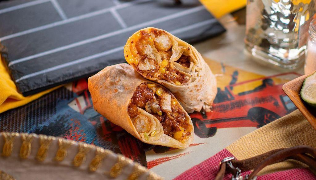Fried Chicken And Gravy · flour tortilla rolled up + stuffed with fried chicken, mozzarella cheese, tots, corn, brown gravy.