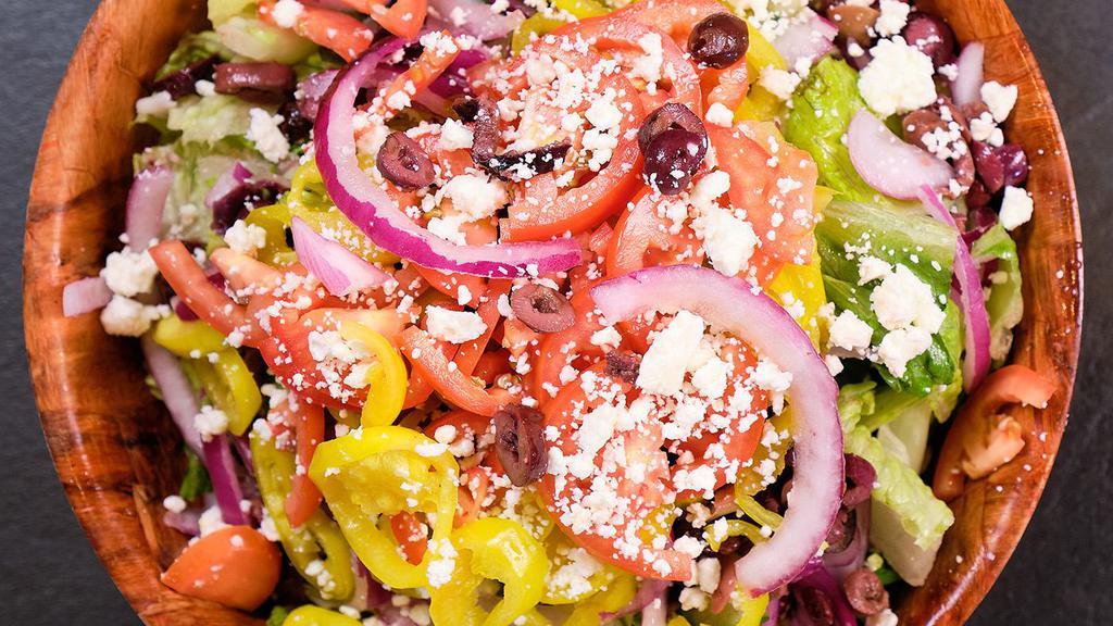 Signature Greek Salad · Crisp romaine lettuce, fresh tomatoes, red onions, feta cheese, cucumbers, Kalamata olives, and banana peppers.