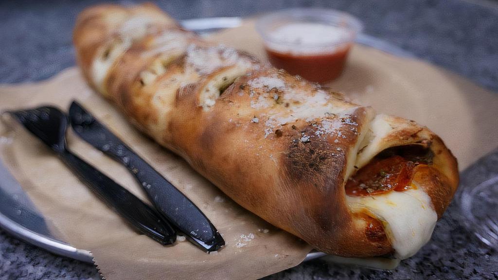 Stromboli · Baked Roll.  pepperoni, mozzarella, ham, red onions, green peppers, parmesan, garlic. served with side of marinara