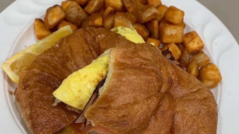 Croissant Sandwiches · Scrambled eggs, ham, tomatoes & cheddar cheese served with home potatoes.