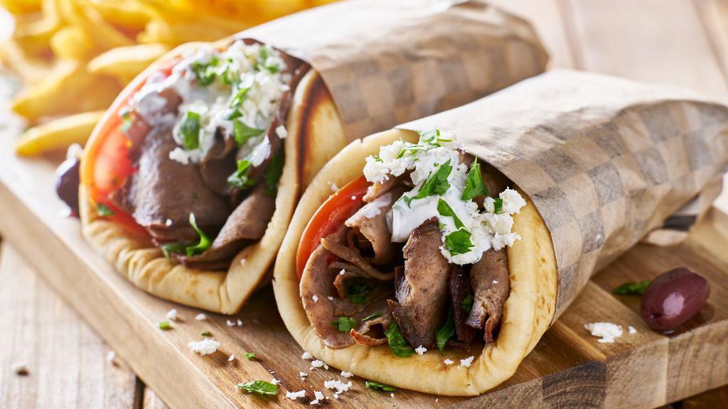 Gyro Wrap · Delicious juicy gyro meat with lettuce, onions, tomatoes, salata, tzatziki sauce all wrapped up in a pita bread.