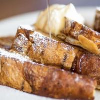 French Toast · Four halves of cinnamon swirl French toast sprinkled with powdered sugar.
