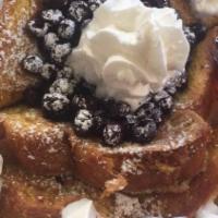 Blueberry French Toast · Four halves of French toast topped with warm blueberries and whip cream.