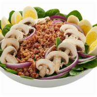 Spinach Salad · Tender baby spinach greens topped with crumbled bacon, red onion, fresh mushrooms, and hard-...