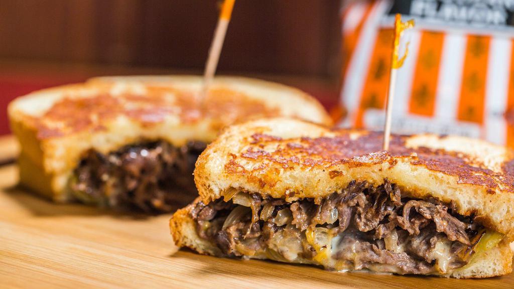 Southwestern Tri Tip Melt · Marinated tri-tip served on Parmesan-crusted sourdough with a blend of melted Cheddar and Pepper Jack cheeses, drizzled with southwest sauce, grilled onions, and an Ortega chili.